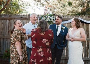 Candid moment of wedding guests laughing together during an outdoor celebration.