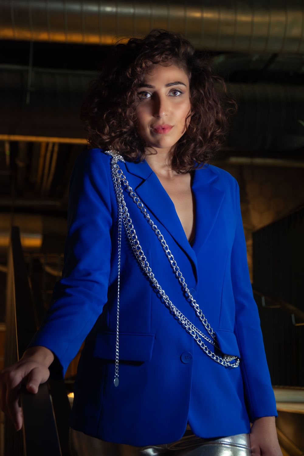 Woman in high-fashion modest blue suit and silver pants, posing in Hasselt.