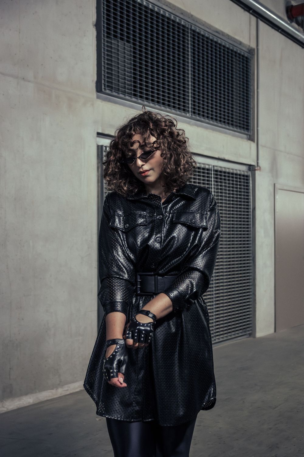 Model in a modest dress and gloves, striking a pose in Hasselt, showcasing elegance and style.