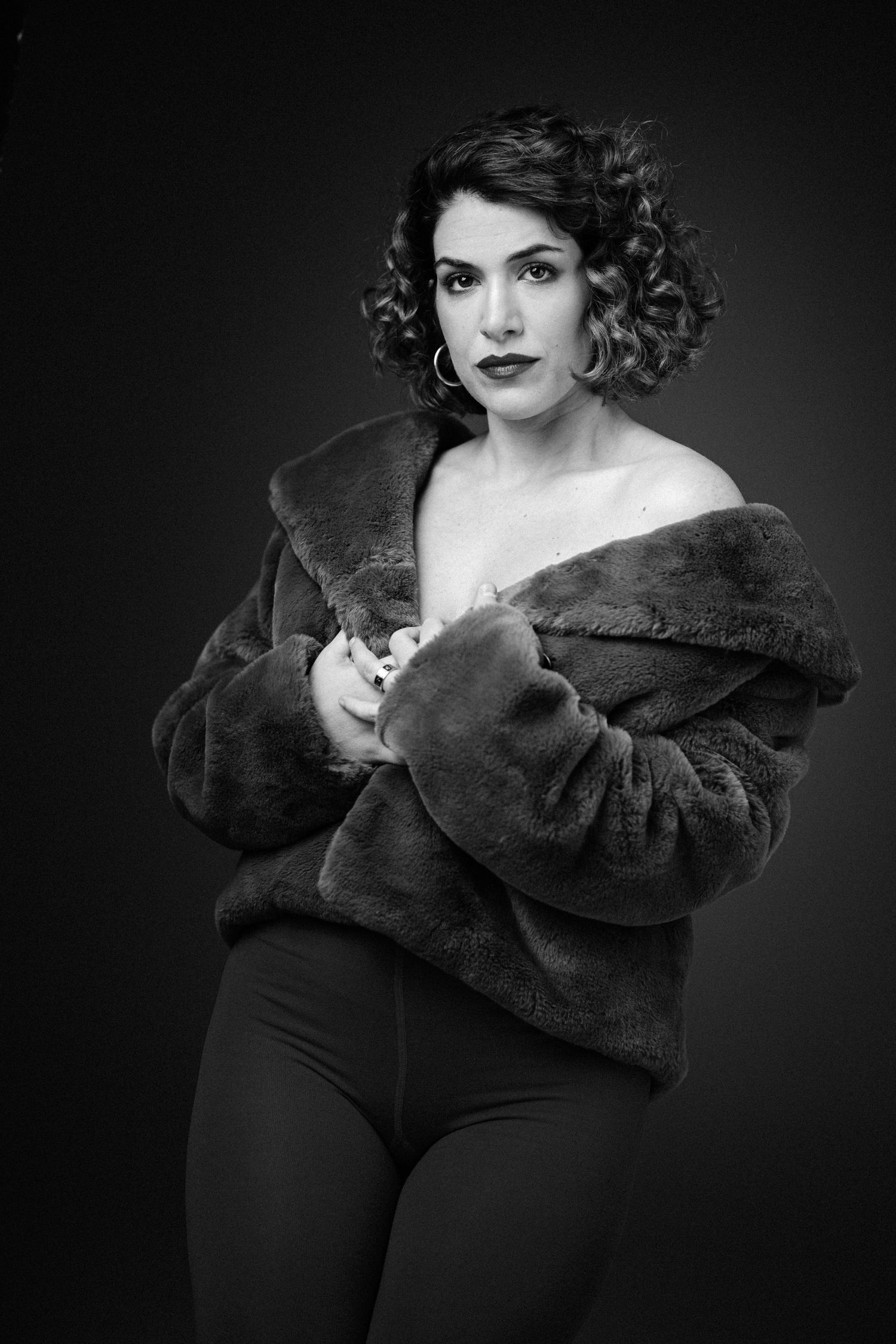 Black and white portrait with dramatic lighting wearing dark fur wrap.