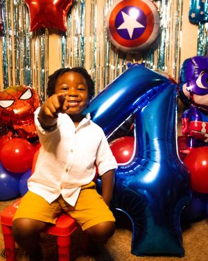 Birthday celebration with superhero theme featuring Captain America shield and festive balloons.