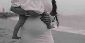 A close-up black and white capture of bare feet and white fabric at the beach.