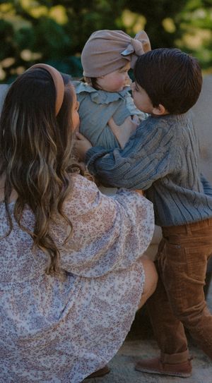 A touching family moment outdoors featuring soft earth tones and warm knit clothing.