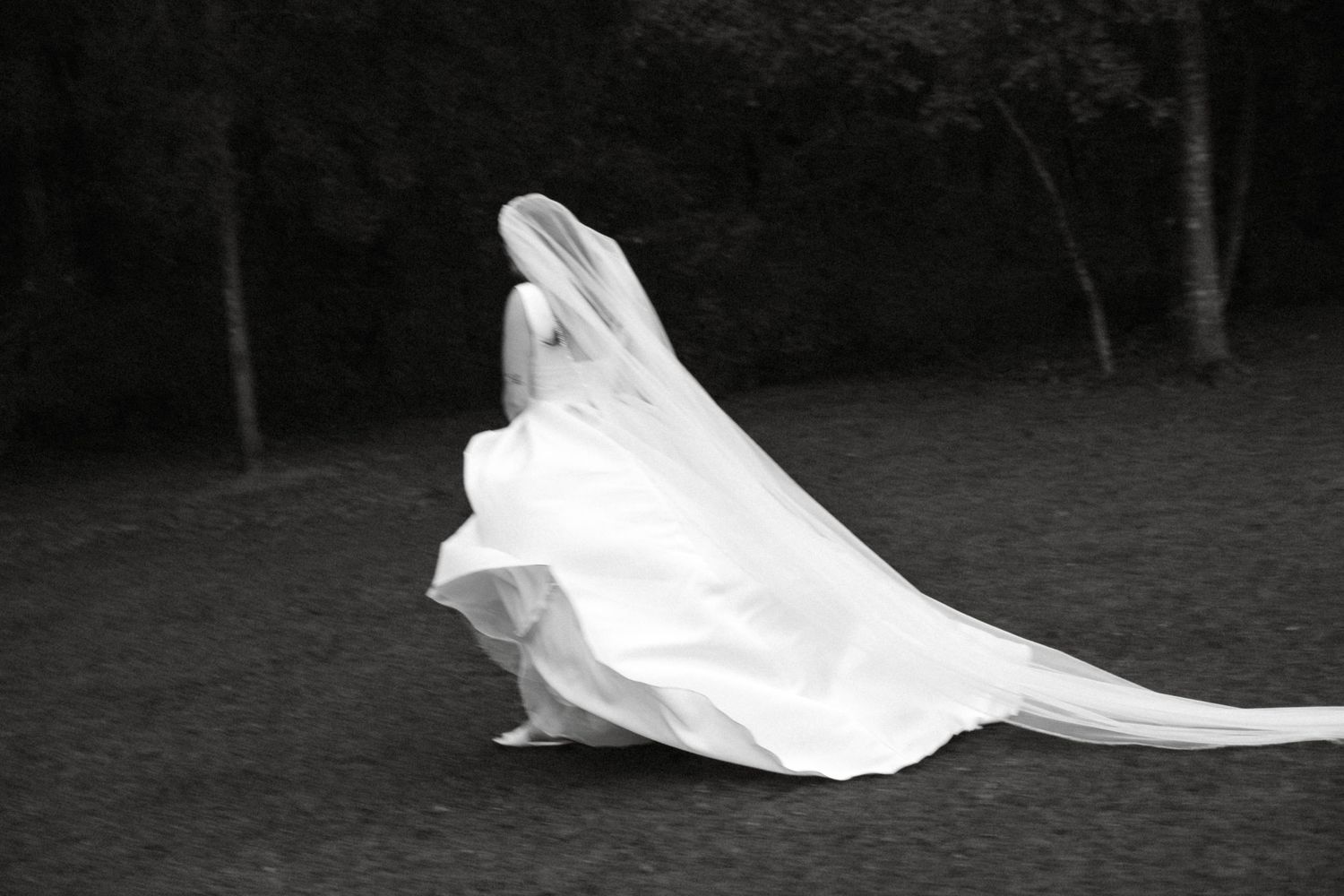 A series of black and white photos showing a white flowing fabric or veil moving gracefully in the wind.