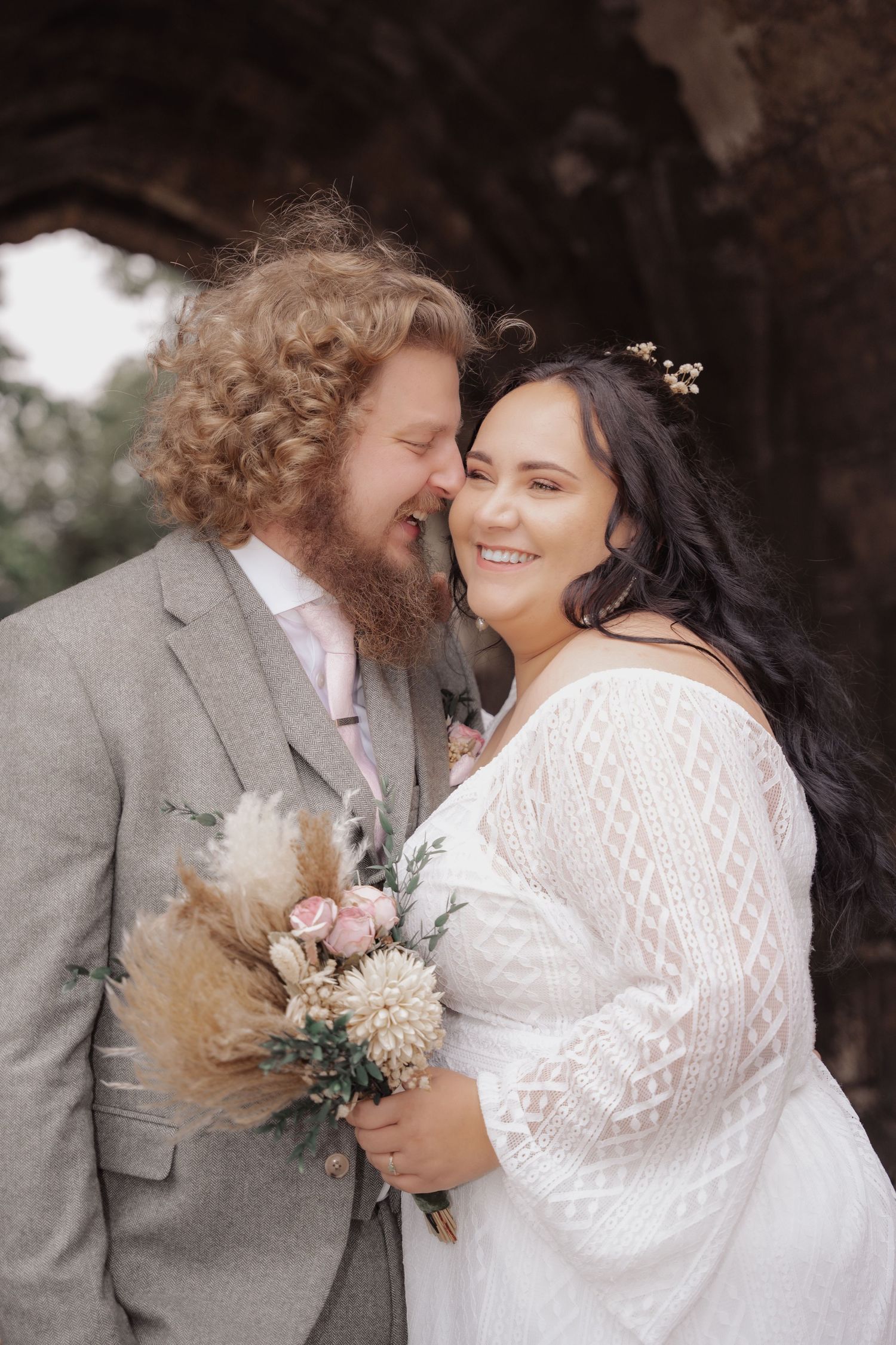 Romantic wedding portraits of newlyweds holding bouquets of dried flowers and pampas grass.