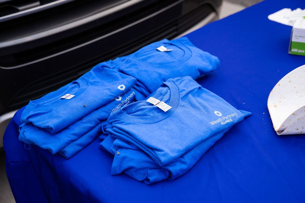 Bright blue t-shirts neatly arranged on a dark blue table surface.