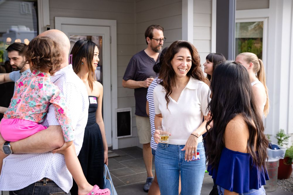 People socializing on a covered porch during a casual outdoor gathering.