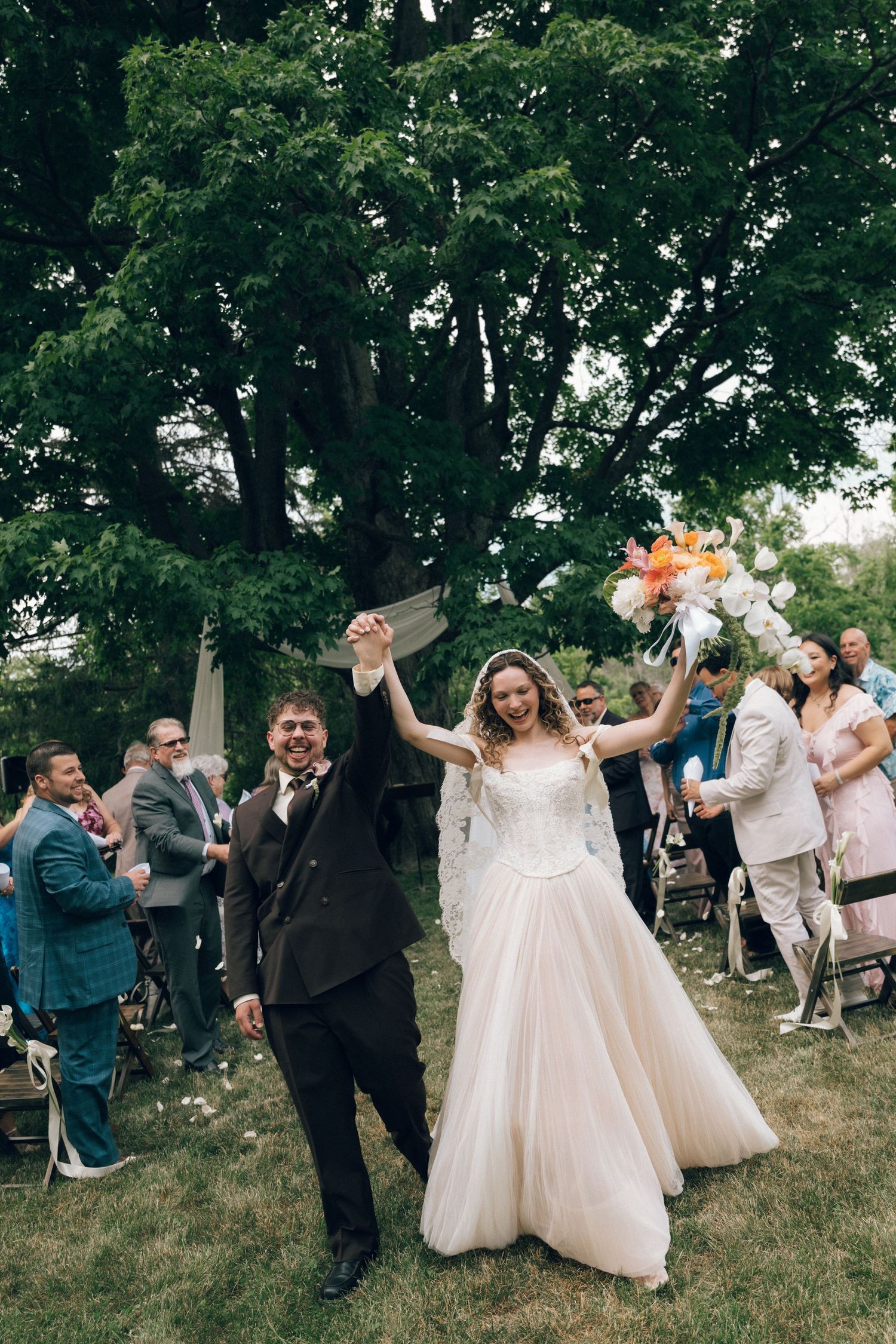 Joyful bridal party shares a candid laughing moment in black and white photography.
