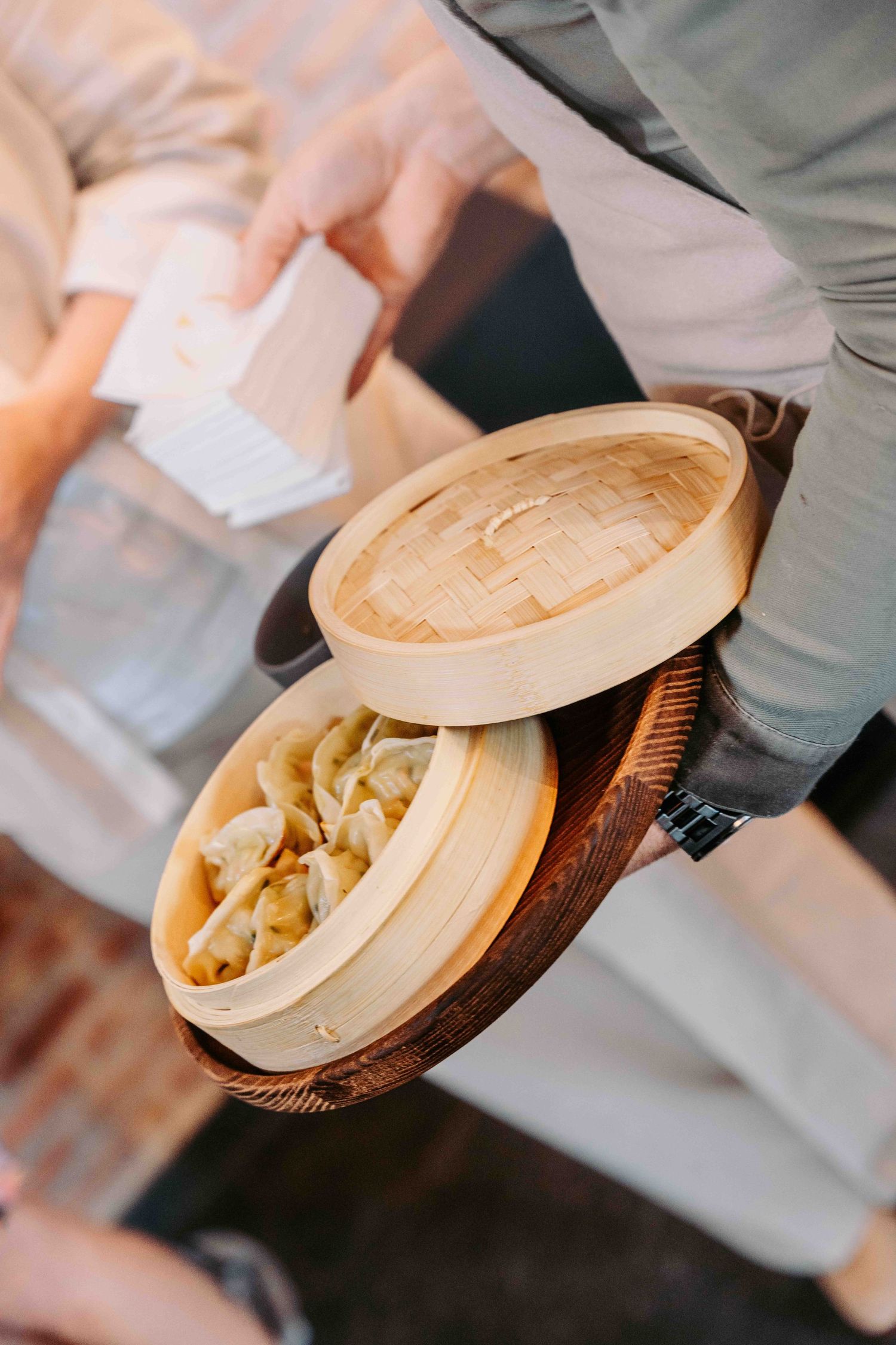 A traditional bamboo steamer basket filled with dumplings being served at a restaurant.