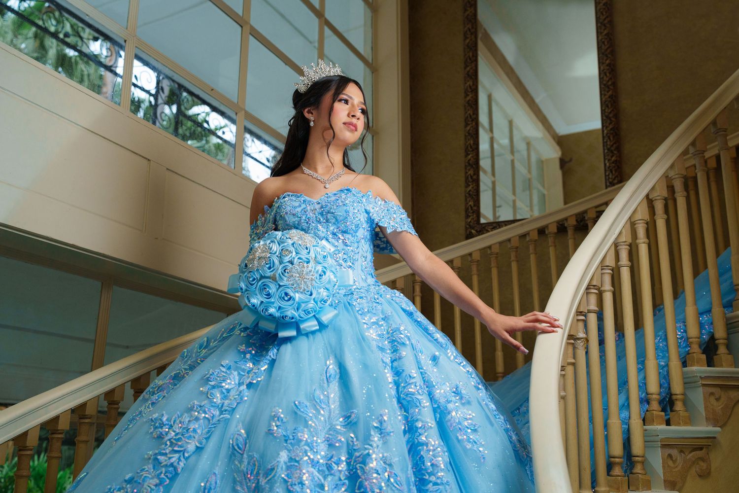 Light blue princess gown with delicate details photographed on elegant wooden staircase.