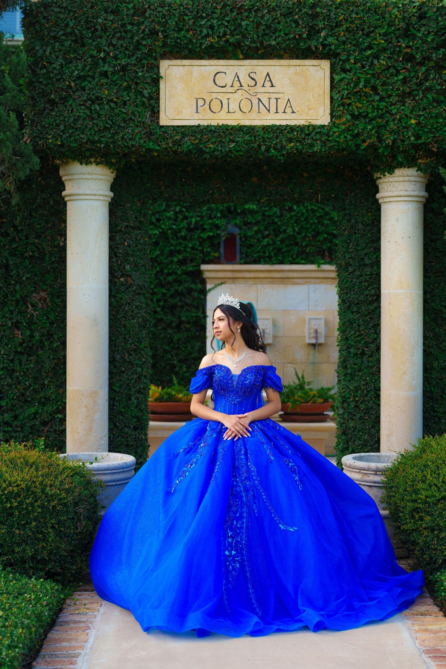 A majestic blue ball gown spreads dramatically across Casa Polonia's elegant columned entrance way.