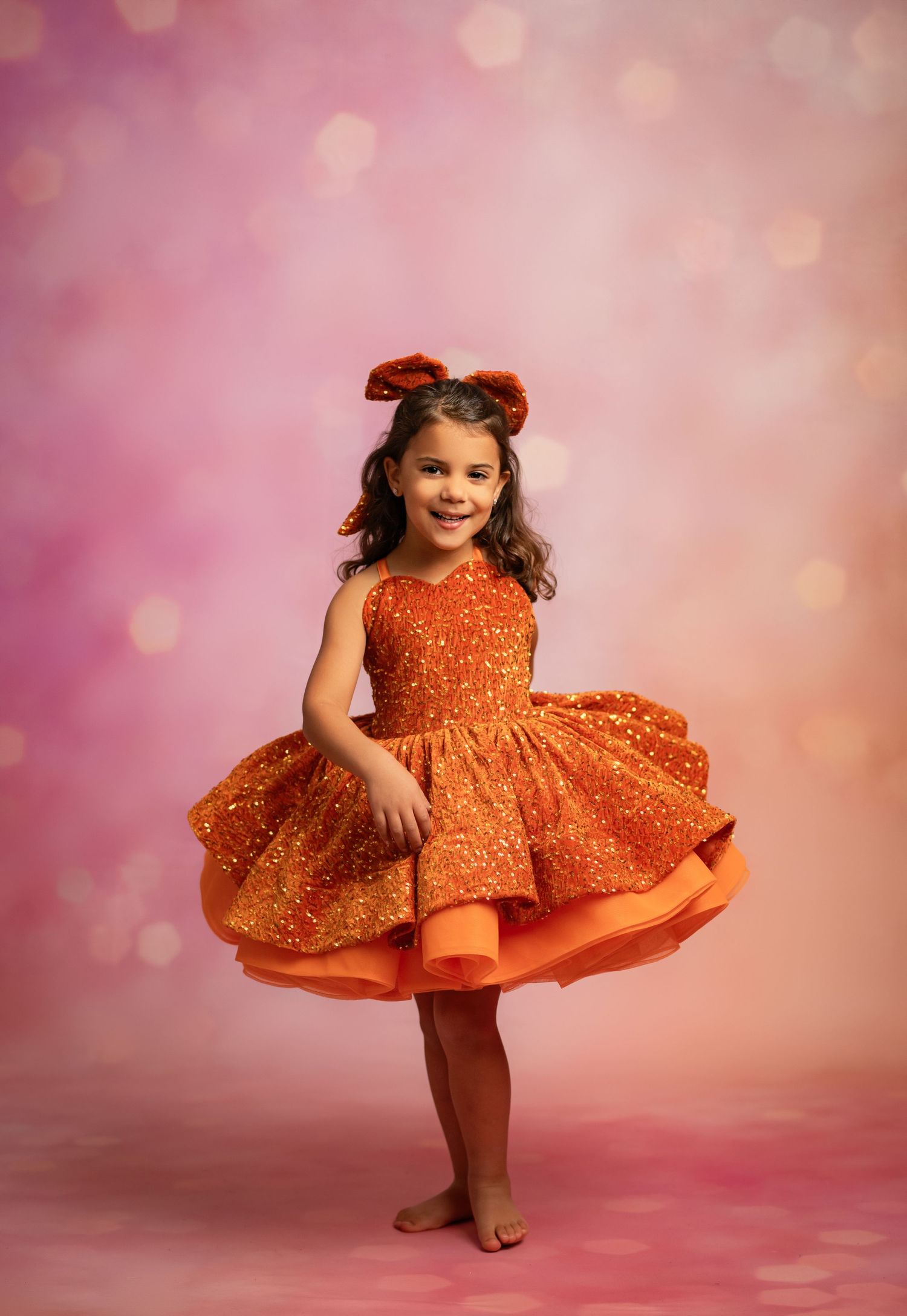 Romantic brown tulle dress captured against dark moody backdrop with dramatic lighting.