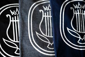 Row of stylized lyre or harp logos printed in white on dark fabric.