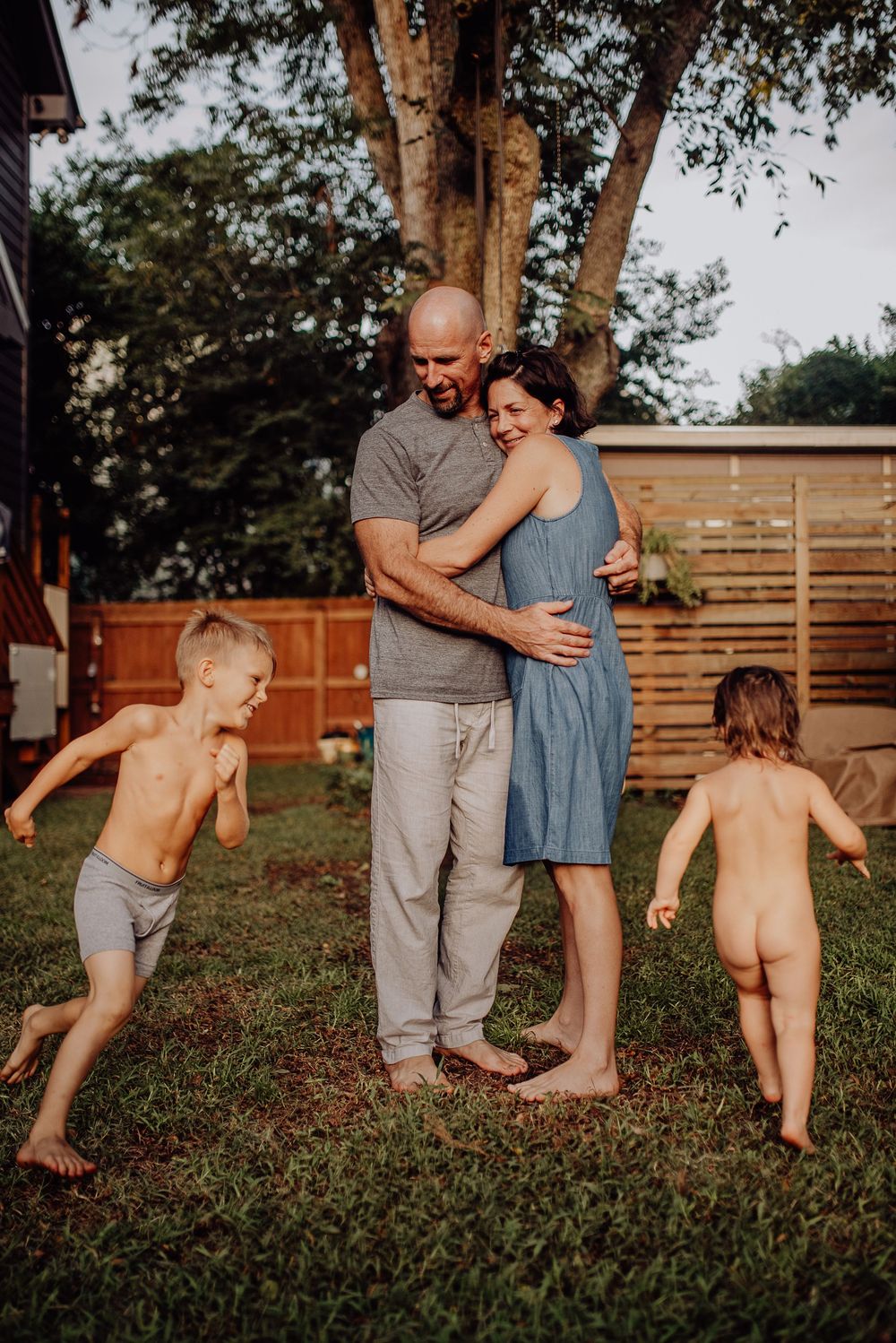 A sequence of outdoor playful moments between family members as they walk and interact in their backyard garden.