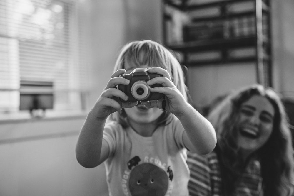 A series of black and white photographs showing people taking pictures with various cameras and equipment.