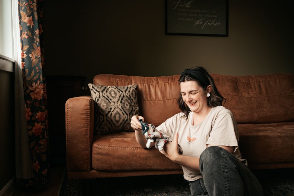A sequence of photos showing someone folding laundry with while sitting on a brown leather couch.