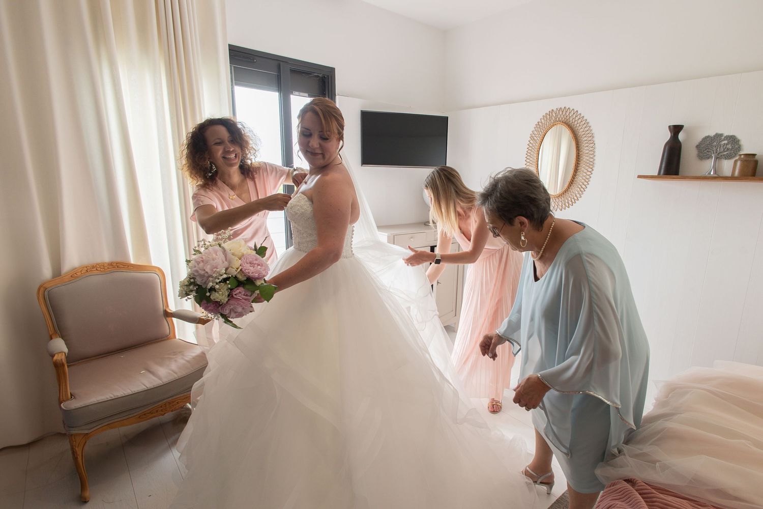 Moment complice des préparatifs de la mariée entourée de ses proches à la Villa 180 à La Rochelle, photographe mariage bord de mer.