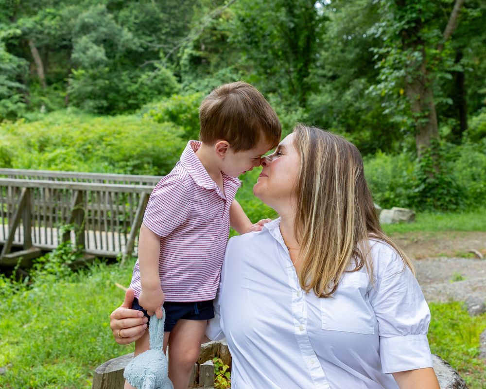 A mom & son pose candidly on the grounds of Wayside Inn Grist Mill during a family photos in Sudbury, MA with Lisa West Photography.