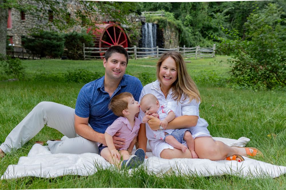 A family poses on the grounds of Wayside Inn Grist Mill during a family photos outside  Boston, MA with Lisa West Photography.