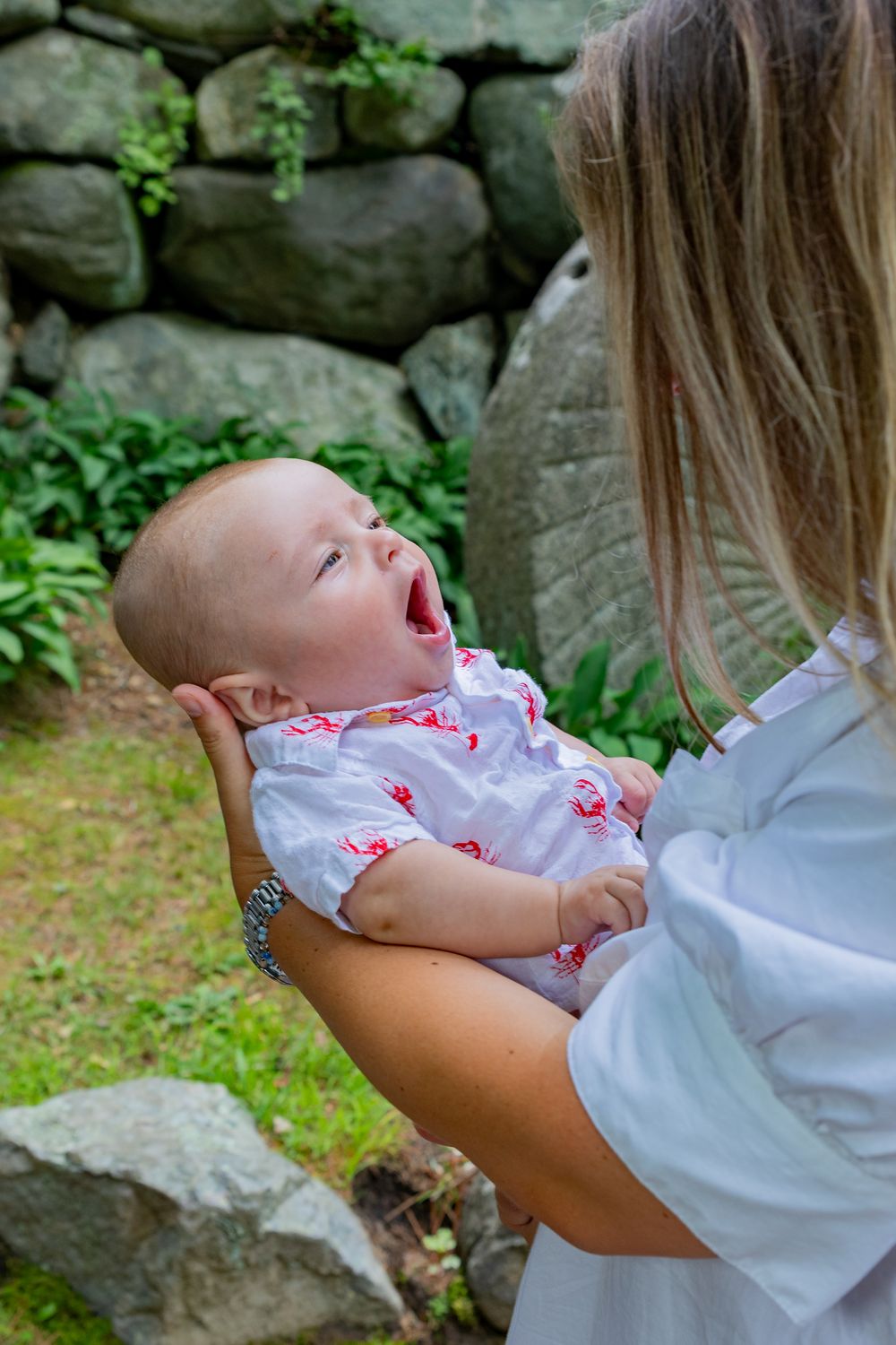 A baby boy yawns during family photo session during a at the Wayside Inn Grist Mill during a in Sudbury, MA with Lisa West Photography.