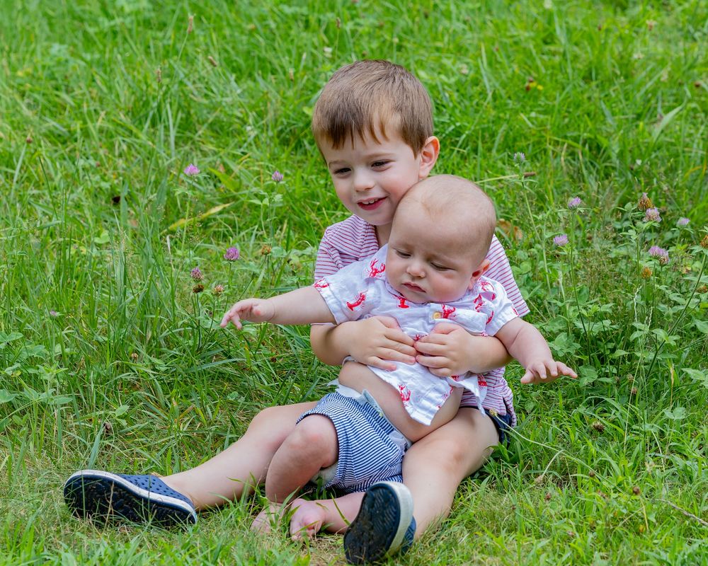 Brothers snuggle during a family portrait session in Sudbury, MA outside of Boston with Lisa West Photography