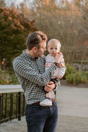 A sweet moment captured on a wooden deck during a fall afternoon.