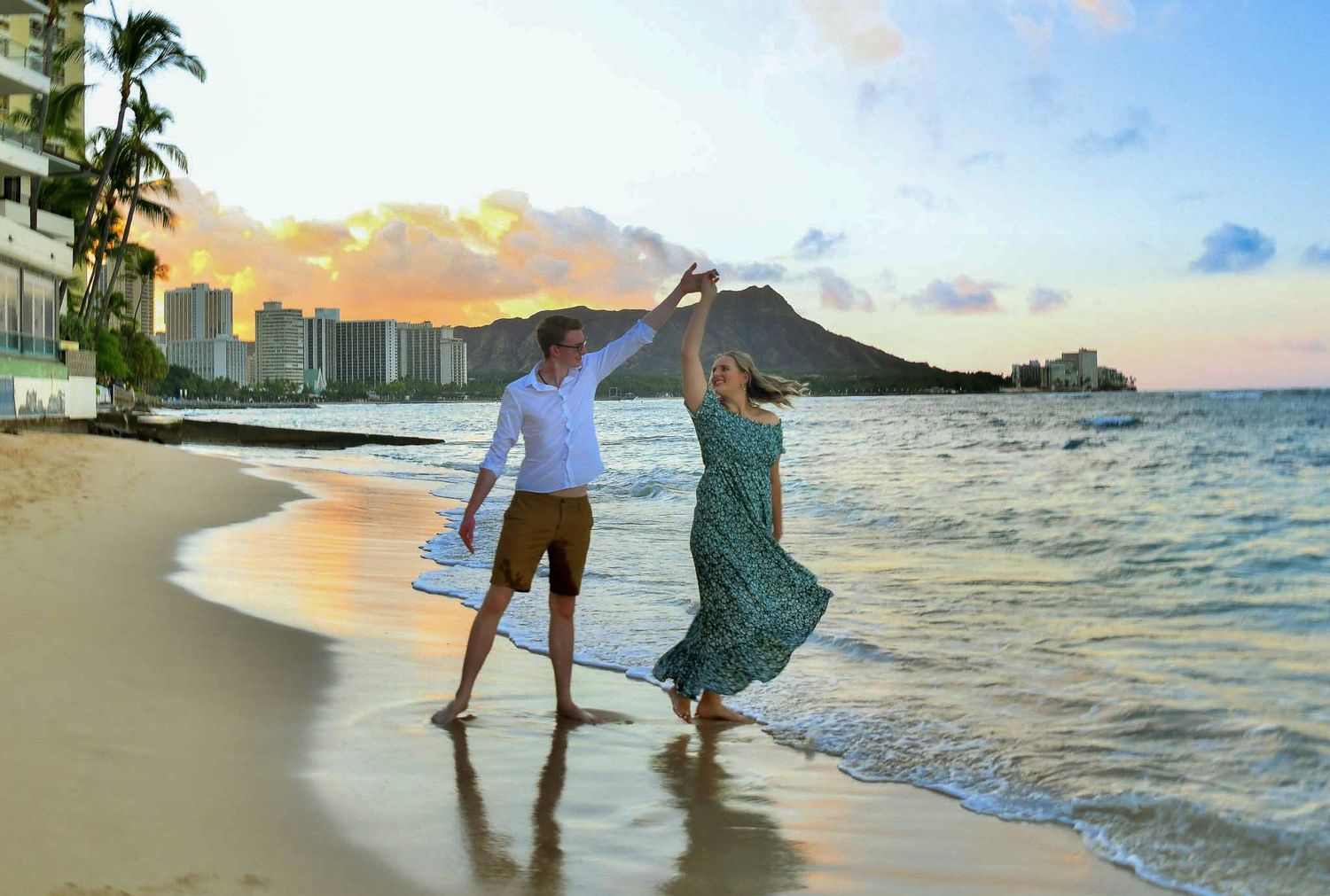 Photo shoot session with couple dancing together during sunrise on Waikiki Beach with Diamond Head mountain in the background.