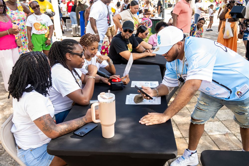 Attendees gathering around long tables at an outdoor community event.
