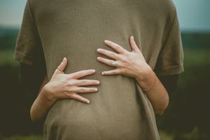 Person in brown sweater gestures with hands against a blurred green background in a sequence of digital photos.