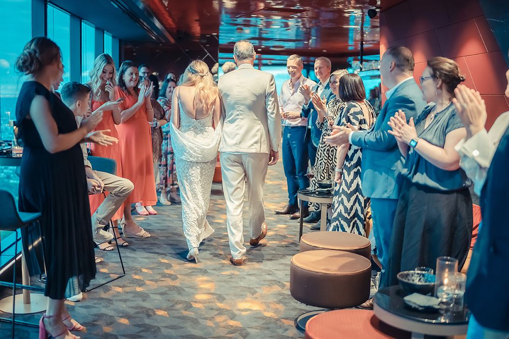Party guests enjoying a celebration in an indoor venue with blue lighting and modern decor.