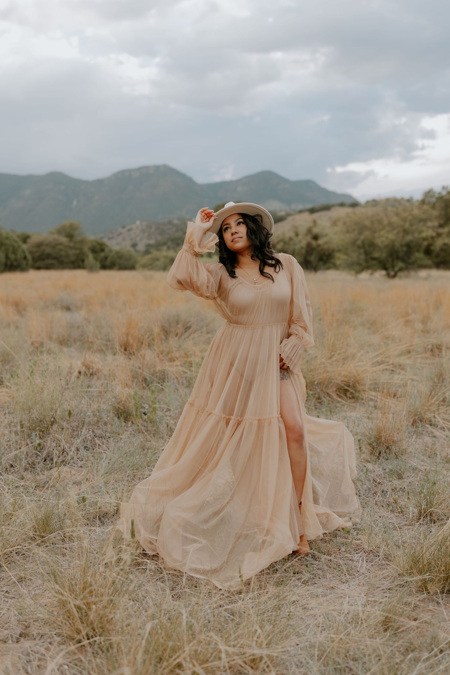 Flowy peach dress photographed in desert landscape with mountains.