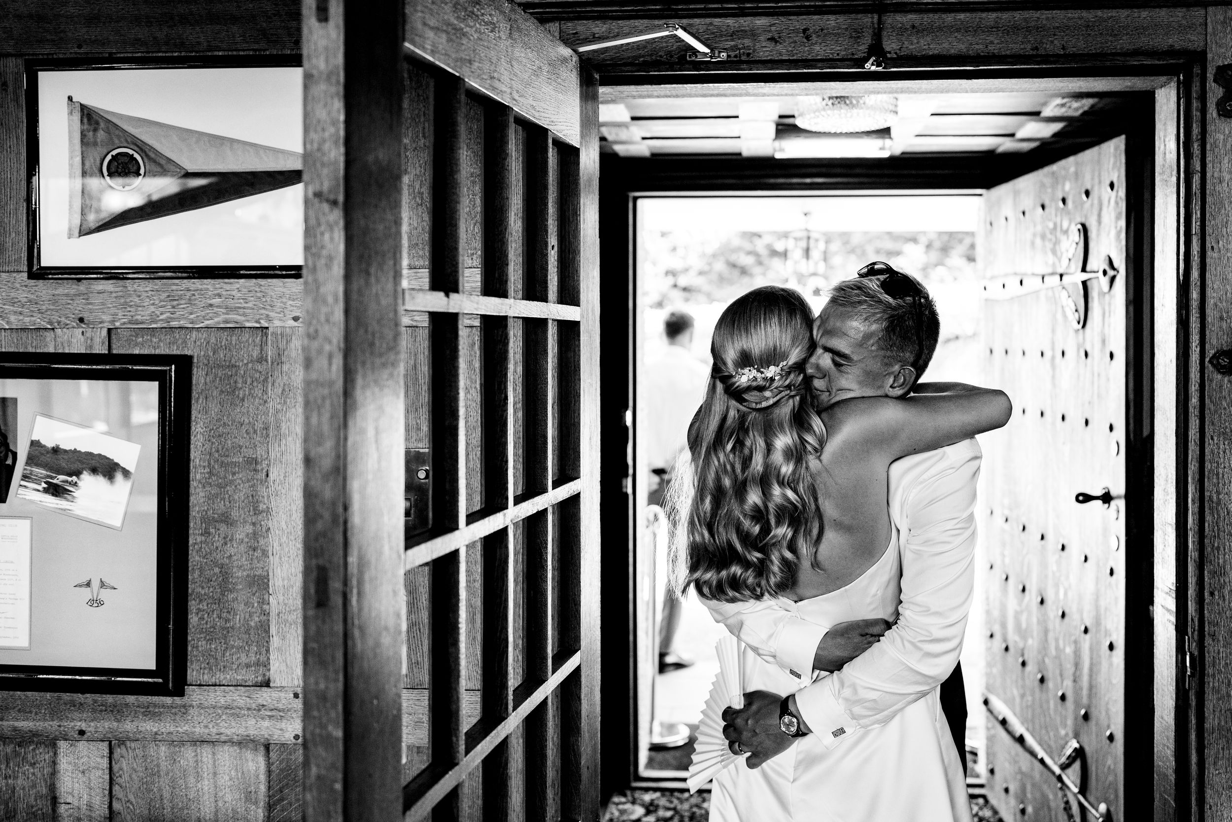 A bride and groom share a tender embrace in a doorway in this black and white wedding photo.