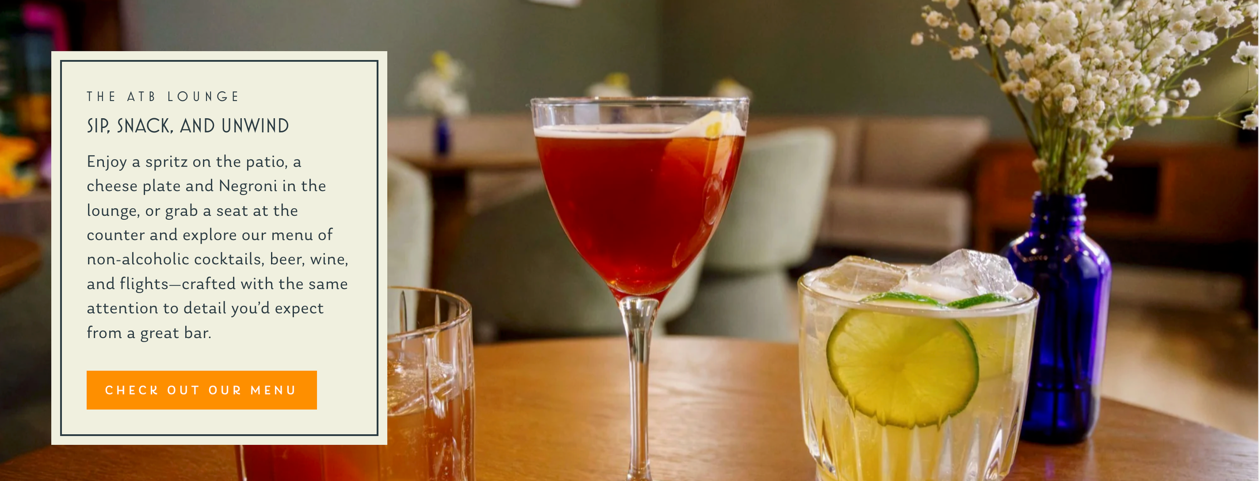 Close-up view of cocktail glasses filled with vibrant drinks on a wooden table with soft natural lighting and vase decor.