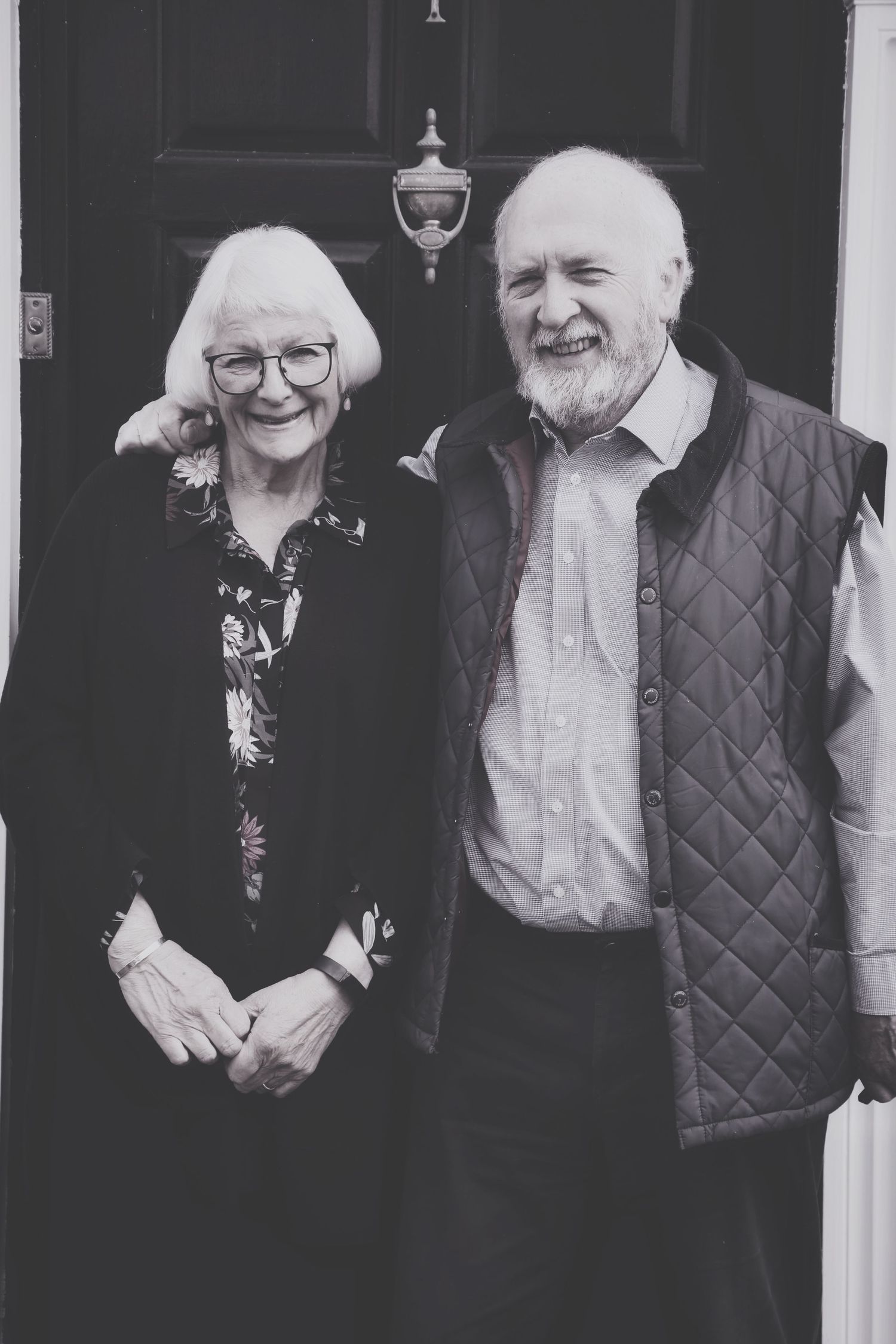 Elderly couple laughing together while standing in front of a brick house. Photographer. Hull. East Yorkshire. Photography