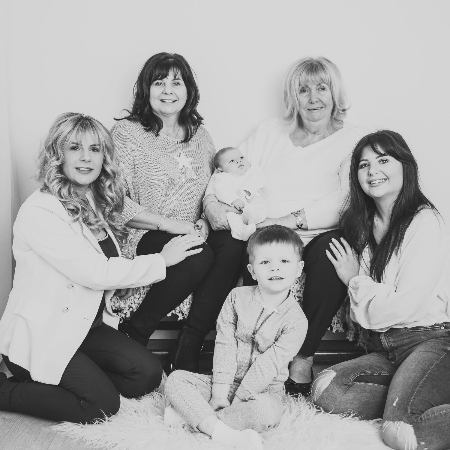Black and white family photo session with multiple generations lying on white backdrop. Photographer. Hull. East Yorkshire. Photography