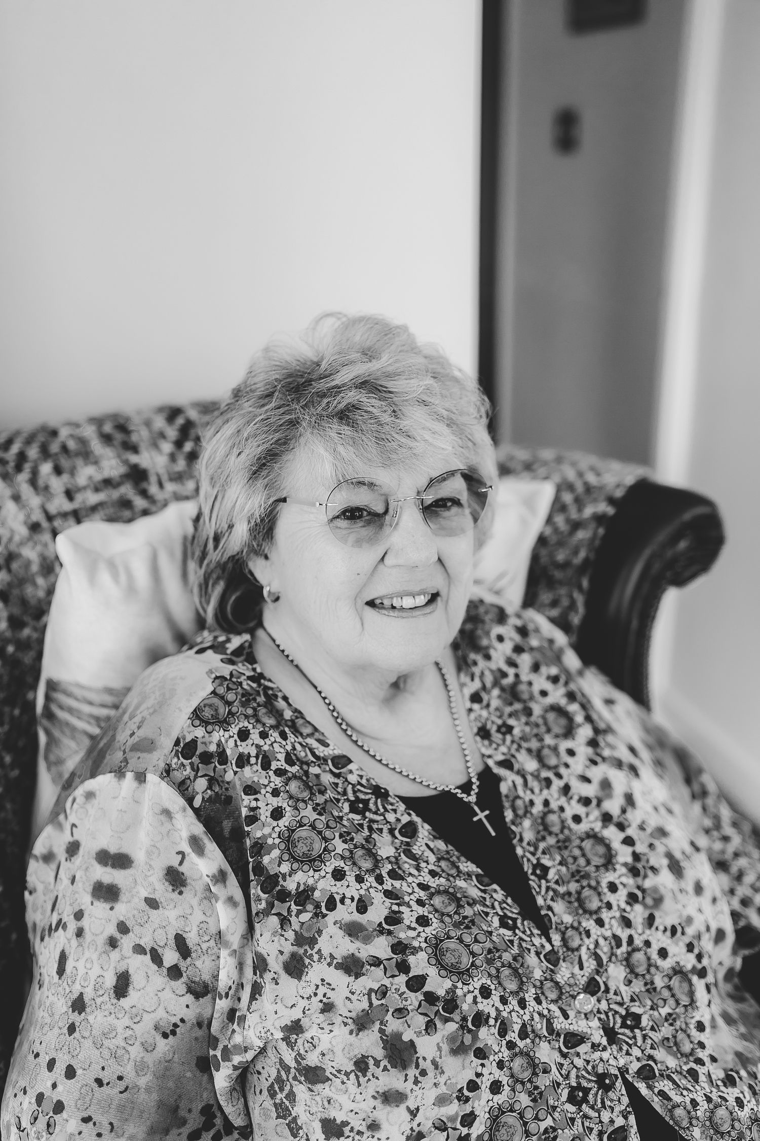 Black and white portrait of someone wearing a floral print dress and smiling. Photographer. Hull. East Yorkshire. Photography