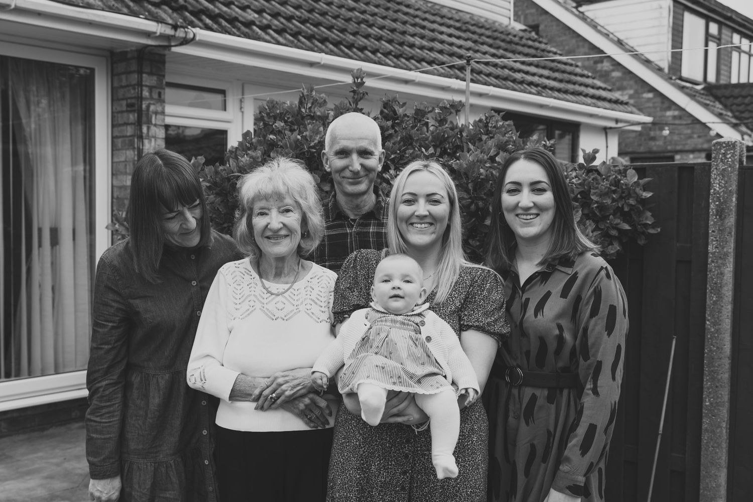 Group photo of family members gathered outside brick house. Photographer. Hull. East Yorkshire. Photography