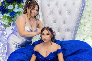 A touching moment captured against an elegant floral backdrop with tufted chair.