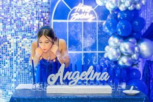 Event setup features elegant blue lighting, balloons and decorative display.