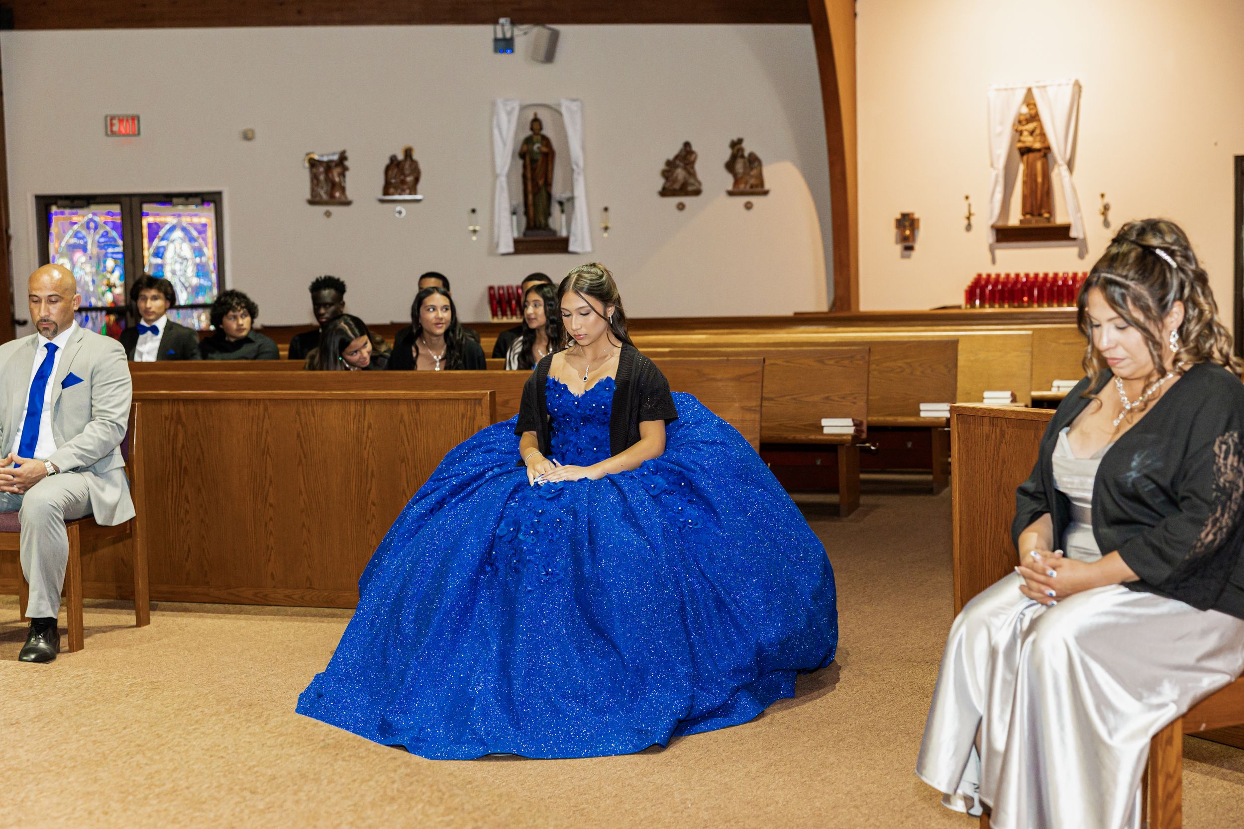 A stunning royal blue ballgown takes center stage in a church setting with decorative wall hangings.