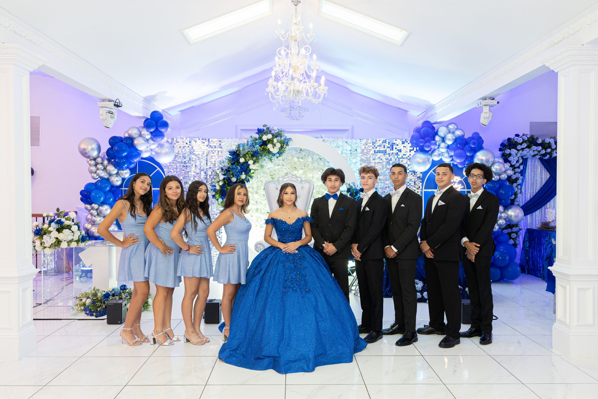 A celebration party with blue decor featuring attendants in formal attire.