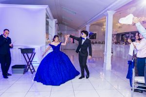 A celebratory dance moment at a quinceañera featuring a stunning royal blue ballgown.