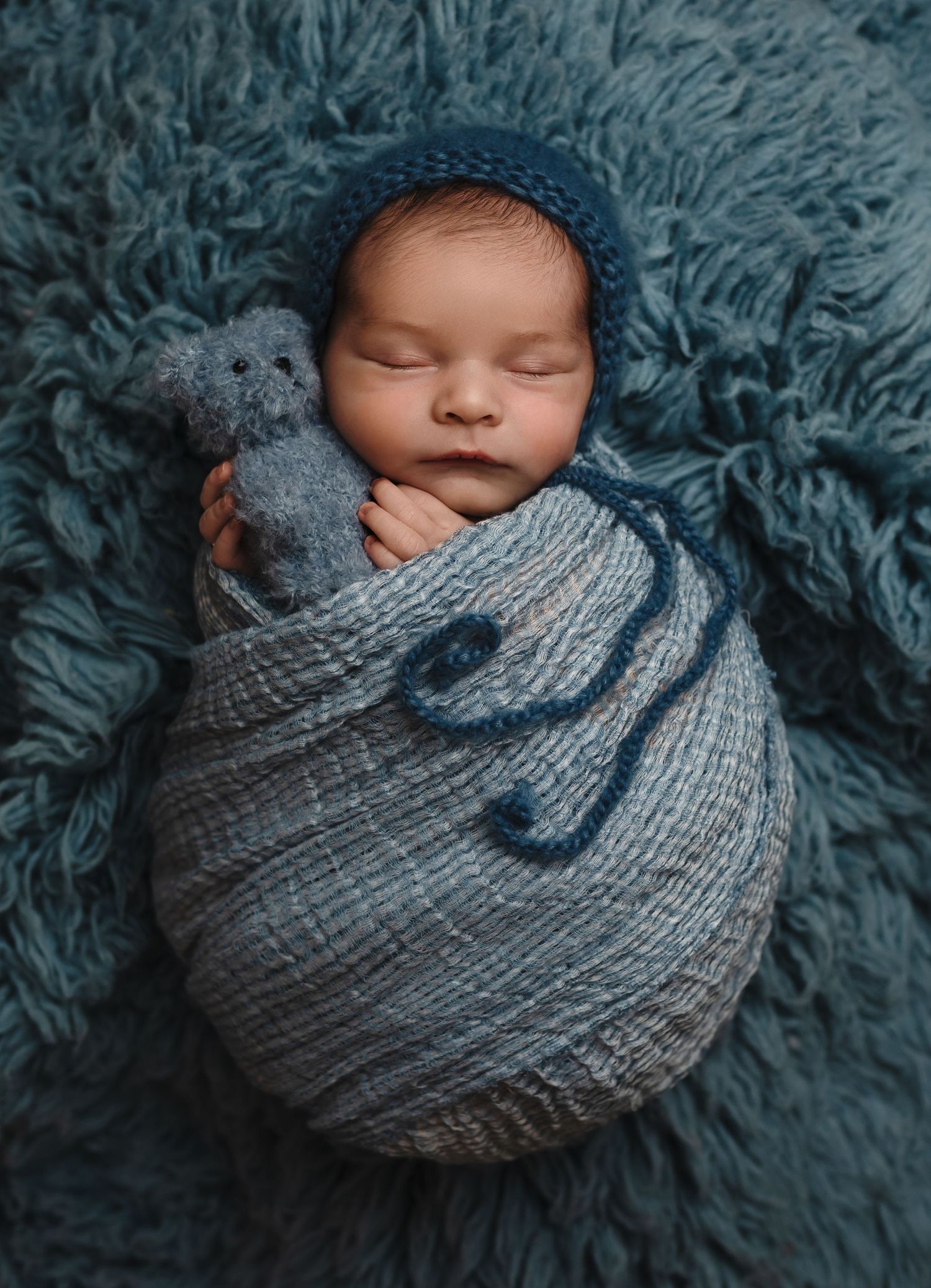 Harrisonburg photographer, newborn, family, baby, maternity, baby girl in blue wrap, hat, and holding blue bear on rug