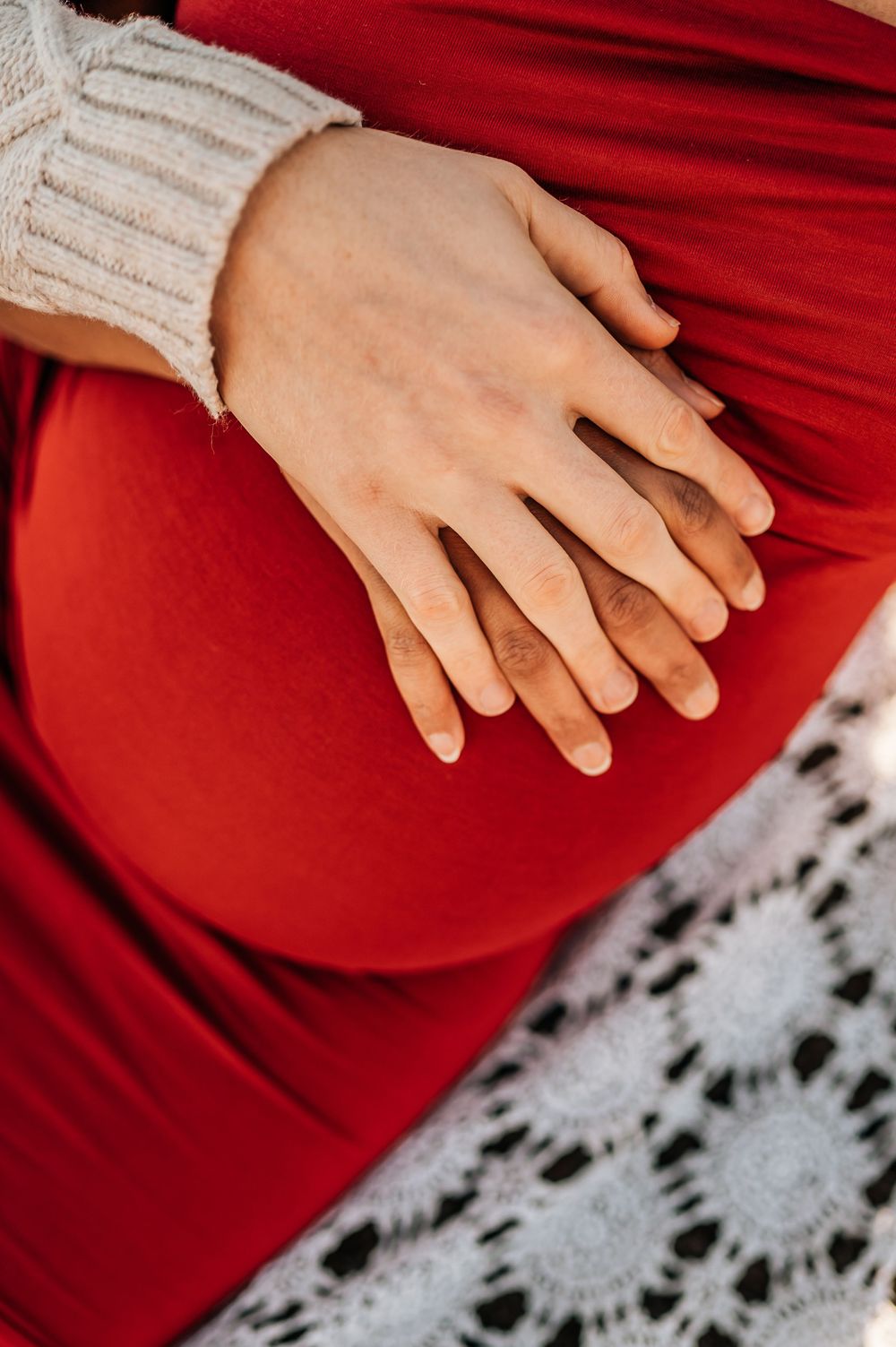 LGBTQ+ pregnant mom with her and her partners hand on belly during a LGBTQ friendly photoshoot in flower mound Texas