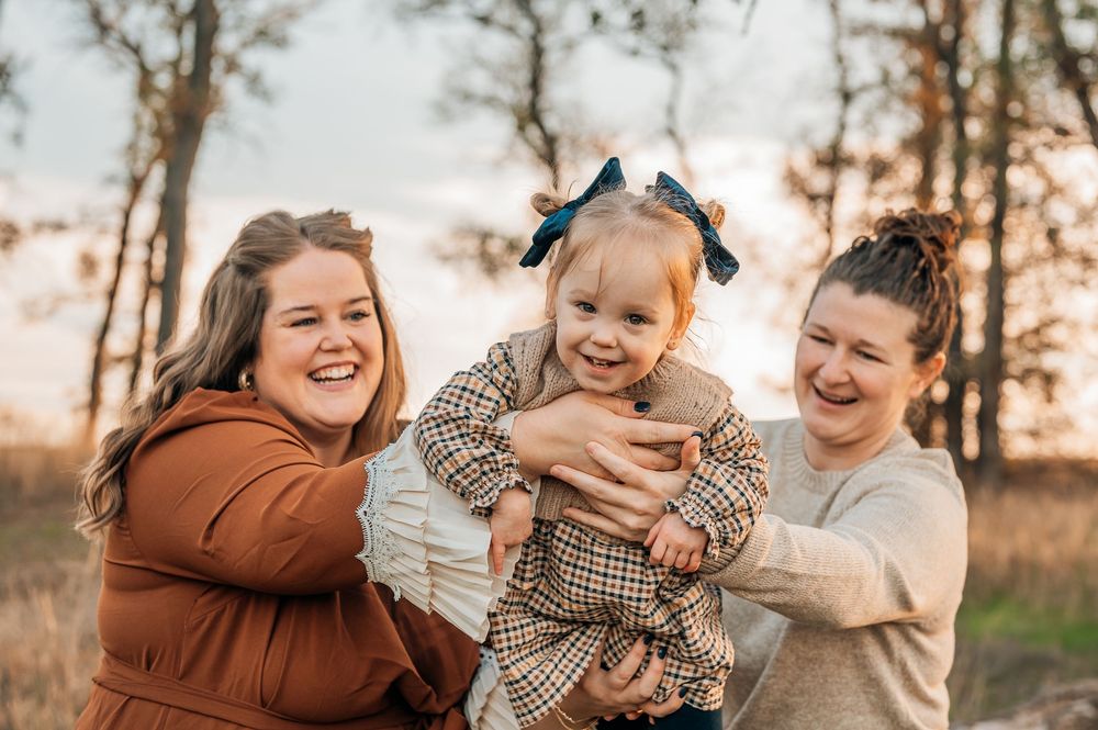 two moms holding their daughter during a lgbtq+ friendly photography session in Fort Worth texas