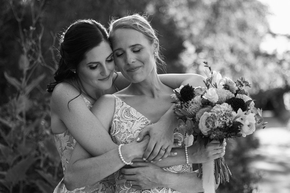 A tender black and white wedding moment captured in a romantic outdoor garden setting.