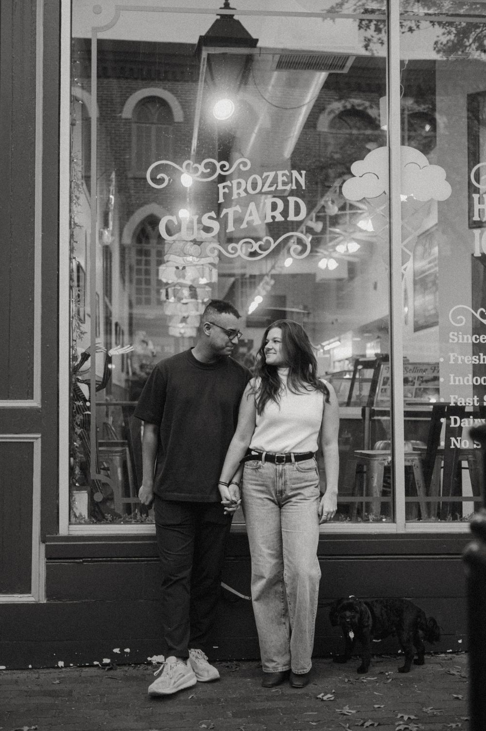 A romantic evening stroll past illuminated storefronts.