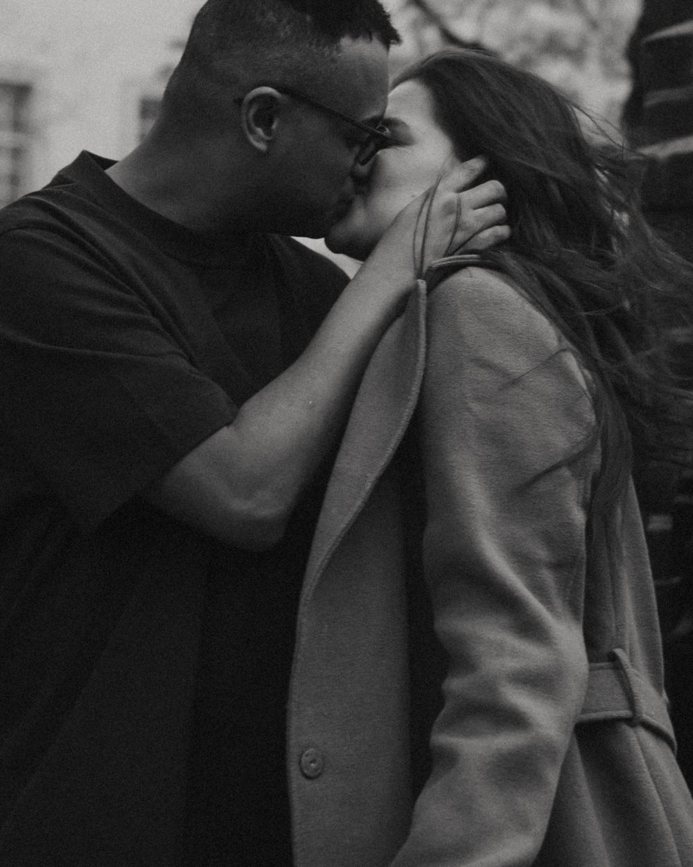 An intimate black and white portrait of a couple sharing a tender moment.