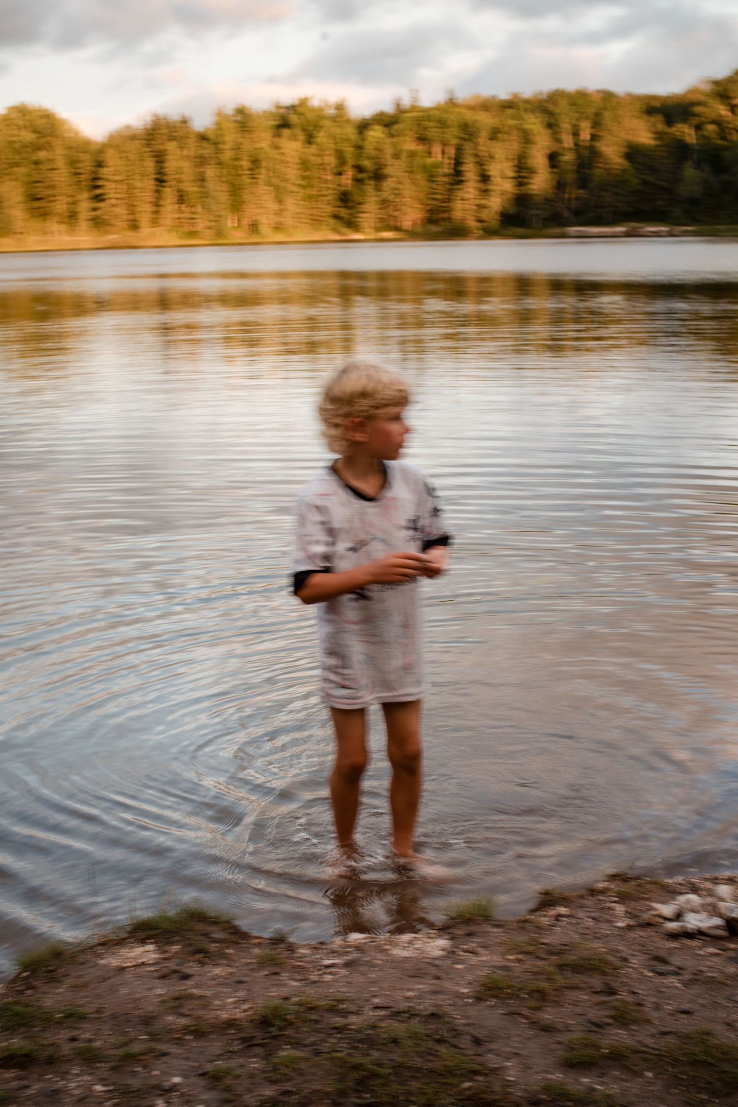 Boy stands in the water during editorial family photoshoot
