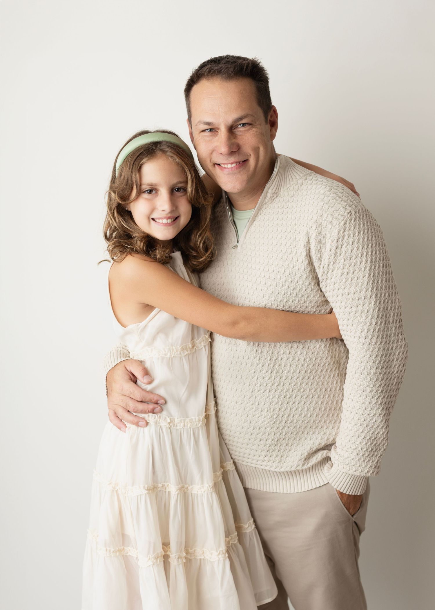 A series of four candid photos showing tender moments between two people in matching cream-colored outfits.